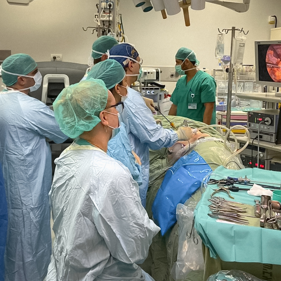 A team of surgeons works in an operating room